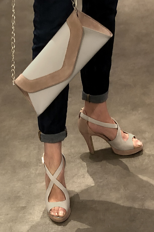 Off white and tan beige women's closed back sandals, with crossed straps. Round toe. Very high slim heel with a platform at the front. Worn view - Florence KOOIJMAN